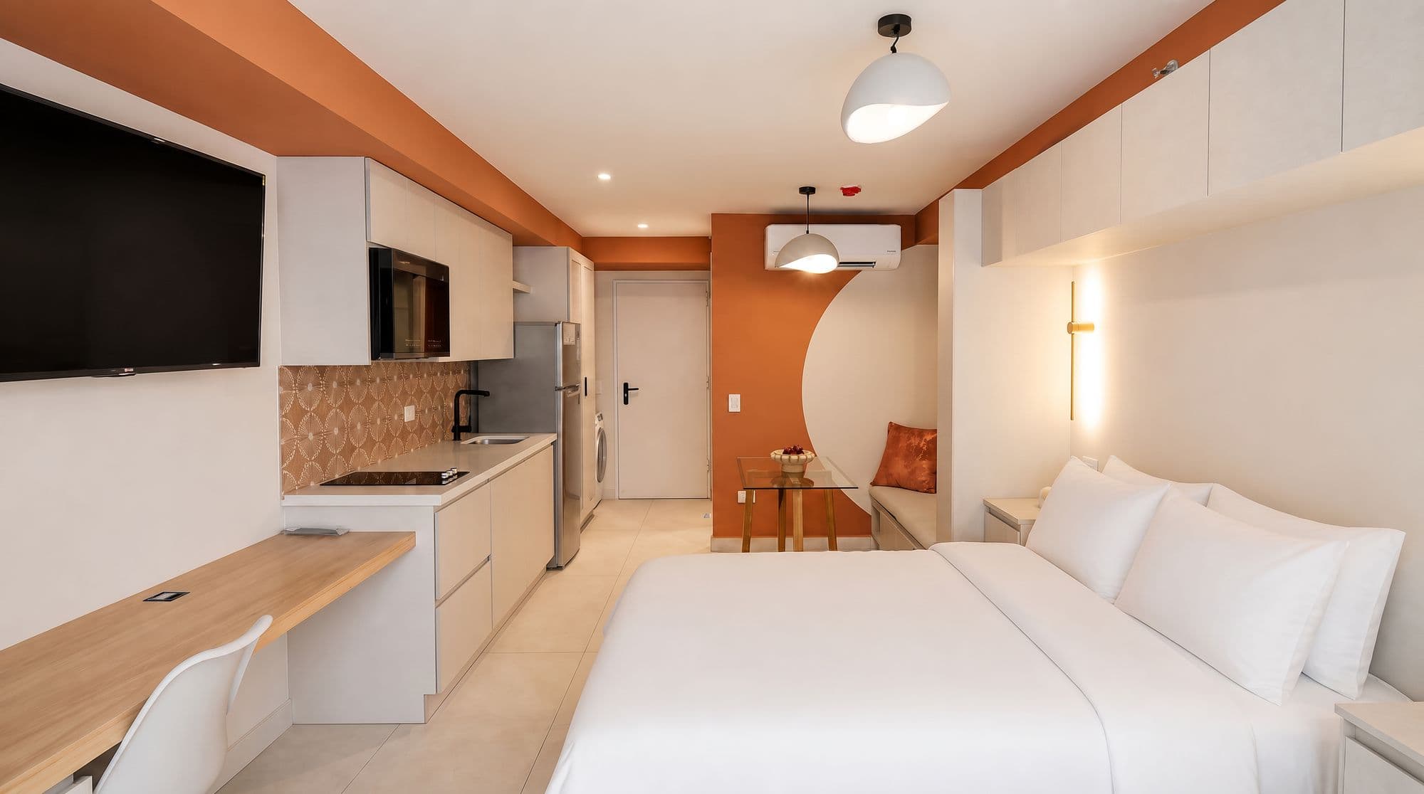 Apartaestudio con viga coral, cocina lineal y muro curvo