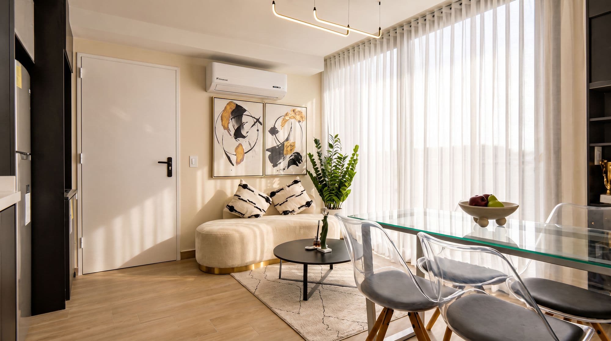 Sala y comedor con mesa de vidrio y cortinas al ventanal