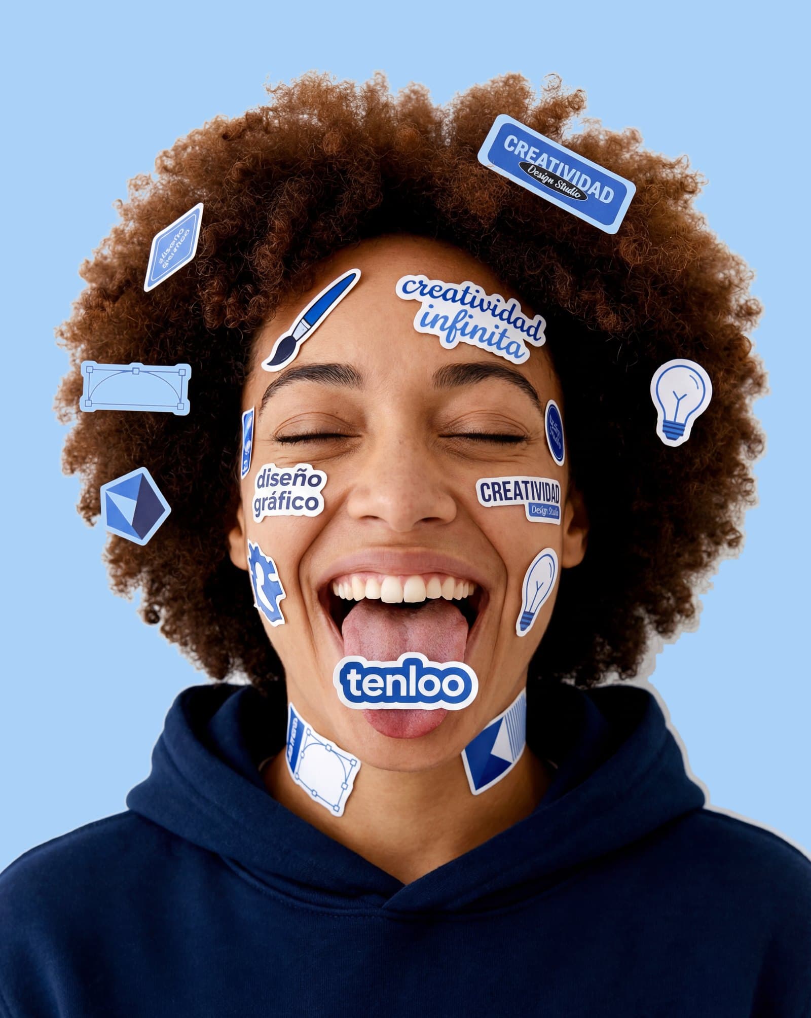 Integrante del equipo de Tenloo con calcomanías de diseño en la cara y sudadera azul con el logo
