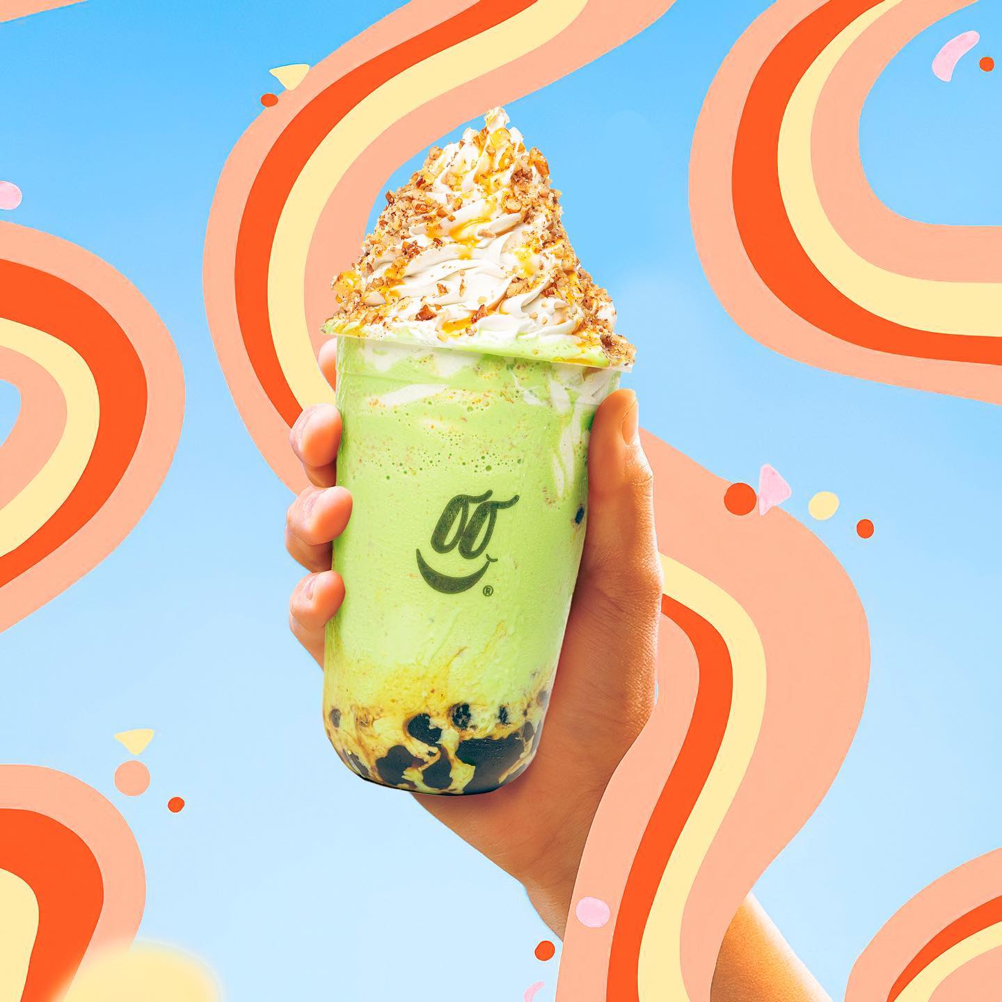 Bubble tea de matcha en la mano sobre un fondo de arcos naranjas