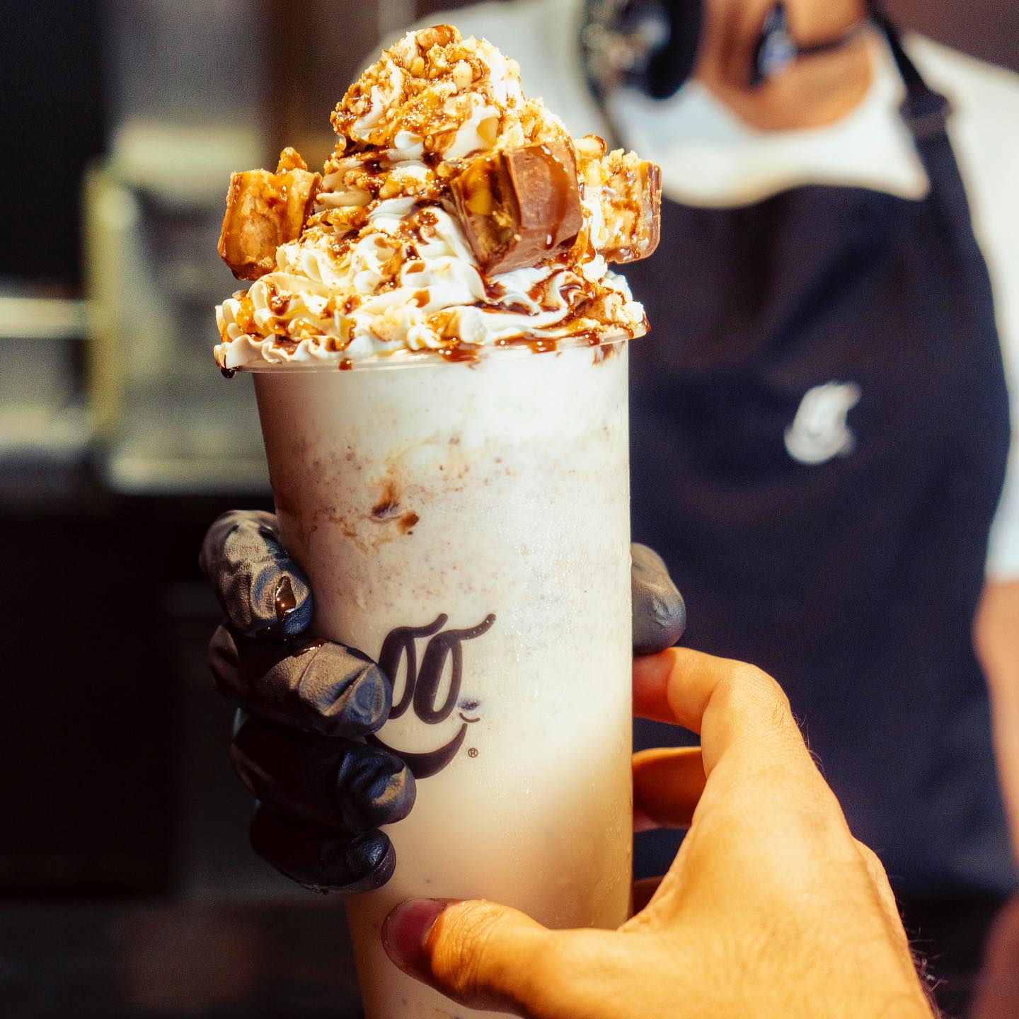 Vaso con topping de caramelo servido en el mostrador de la tienda